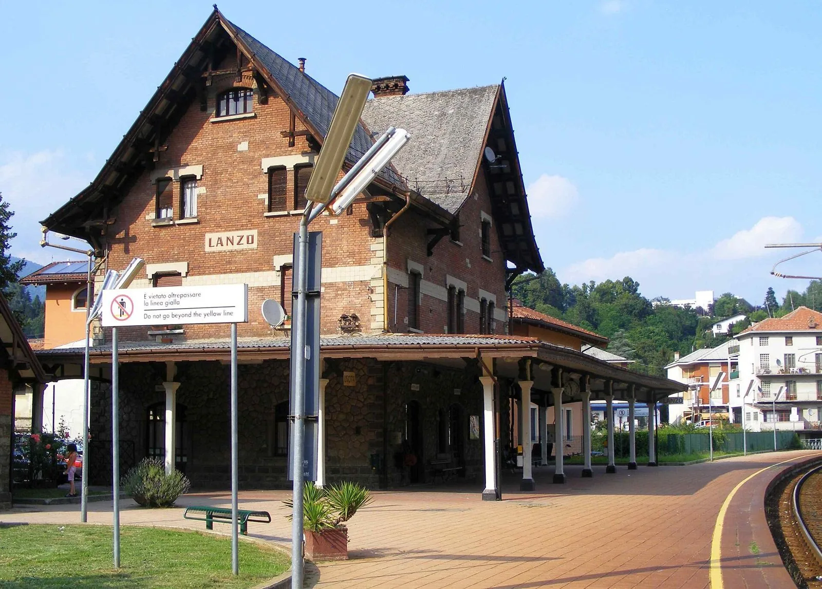 La stazione ferroviaria di Lanzo Torinese, edificio in mattoni con tetto spiovente e pensilina sul binario